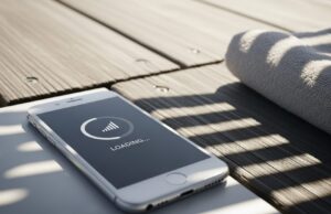 In spiaggia hai le tacche piene ma internet non parte: ecco perché succede davvero Smartphone su passerella di legno con schermo nero e icona di caricamento lento per problemi di rete.