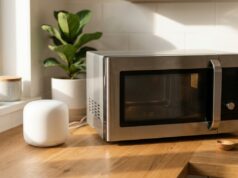 Wi-Fi che rallenta col microonde acceso: il test di 90 secondi che lo dimostra in casa Router wifi bianco vicino a un forno a microonde su un piano cucina in legno