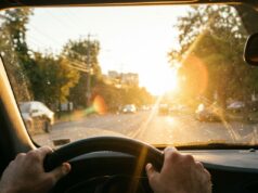 Il sole di settembre torna ad abbagliare chi guida: ecco le fasce orarie a rischio Vista dall'abitacolo di un'auto con il sole basso di settembre che abbaglia il parabrezza durante la guida mattutina