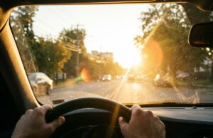 Il sole di settembre torna ad abbagliare chi guida: ecco le fasce orarie a rischio Vista dall'abitacolo di un'auto con il sole basso di settembre che abbaglia il parabrezza durante la guida mattutina