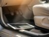 Tablet dei bambini dimenticato in auto: il danno alla batteria che si scopre solo a settembre Tablet bianco appoggiato nel vano piedi di un'auto, vicino ai pedali, illuminato dalla luce calda del sole attraverso il parabrezza