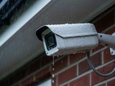 Telecamera da esterno e temporali: dove sigillare i cavi per non bruciarla Telecamera di sorveglianza esterna bagnata dalla pioggia durante un temporale estivo, montata su parete in mattoni