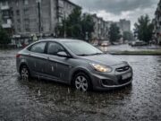Pozzanghera profonda e maltempo in arrivo: cosa fare per non rovinare il motore dell’auto Auto ferma in una pozzanghera profonda durante un temporale, a rischio di colpo d'acqua al motore