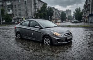 Pozzanghera profonda e maltempo in arrivo: cosa fare per non rovinare il motore dell’auto Auto ferma in una pozzanghera profonda durante un temporale, a rischio di colpo d'acqua al motore