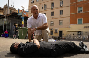 Il metodo Paraldi: chi è davvero Marco Paraldi, il personaggio ispirato al passato di Roncone Luca Zingaretti nei panni di Marco Paraldi chino su un corpo in una scena de Il Metodo Paraldi