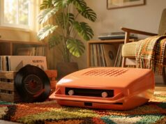 Il mangiadischi in casa: l’oggetto che ha insegnato la musica a una generazione di bambini italiani Mangiadischi vintage arancione anni '70, con dischi 45 giri in una cassetta di legno su un tappeto colorato