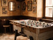 Il calcio balilla nei bar italiani porta un nome che quasi nessuno sa spiegare davvero Tavolo da calcio balilla in un bar italiano d'epoca, pareti calde e locandine vintage