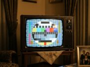 Il monoscopio Rai restava in onda per ore ogni giorno: il motivo per cui nessuno lo spegneva Un televisore a tubo catodico in un salotto di inizio anni Ottanta che mostra il monoscopio a colori, appoggiato su un mobiletto in legno con un centrino di pizzo.