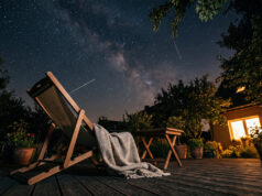 Stelle cadenti stanotte: il motivo per cui in tanti non ne vedranno nessuna Sdraio vuota con plaid su una terrazza di notte, sotto un cielo stellato con alcune scie di stelle cadenti visibili a occhio nudo