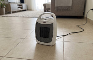 Stufetta elettrica ripresa dal magazzino: il controllo che evita un incendio in casa Stufetta elettrica portatile accesa sul pavimento di un salotto, con il cavo collegato alla presa a muro