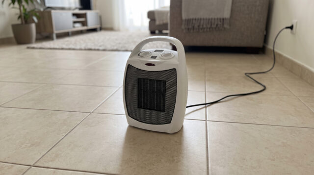 Stufetta elettrica: il controllo prima di accenderla Stufetta elettrica portatile accesa sul pavimento di un salotto, con il cavo collegato alla presa a muro